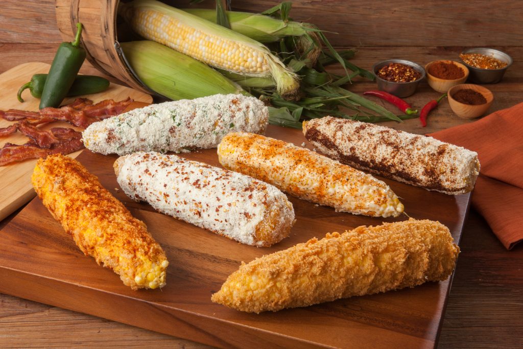 Crazy corn, or Elotes ona wooden cutting board.