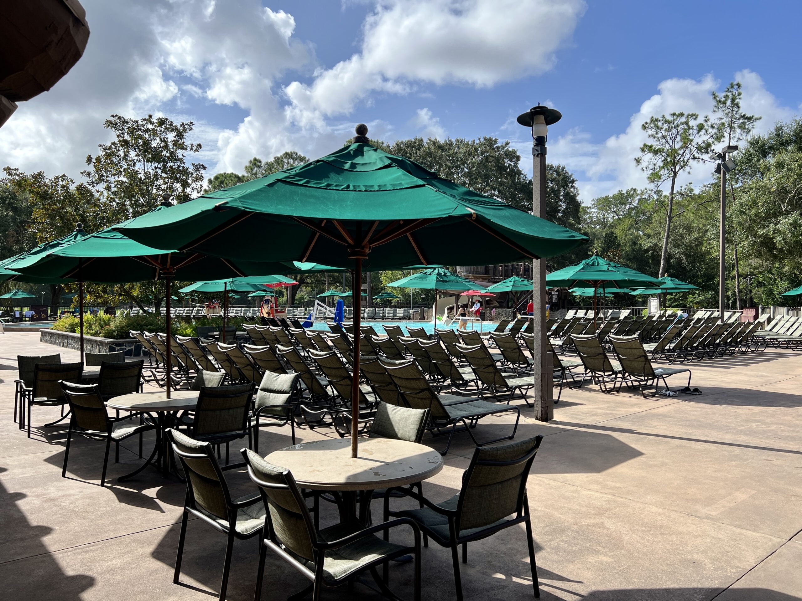 Vibrant pool and hot tub area with ample seating at Disney's Fort Wilderness Resort.